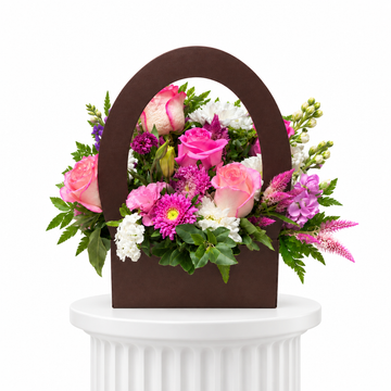 Pink rose handbag flower arrangement on a white fluted pedestal
