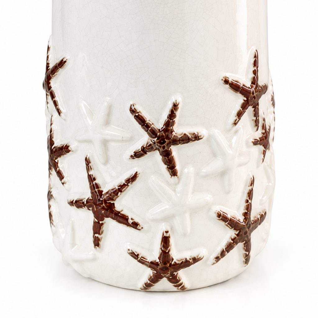 Close-up detail of raised starfish relief, distressed brown accents, and textured white glaze