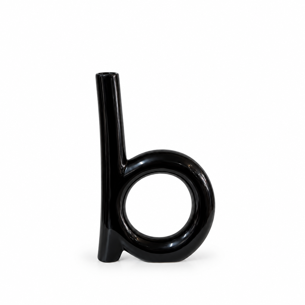 Tall glossy black circular cutout ceramic vase shown empty on white
