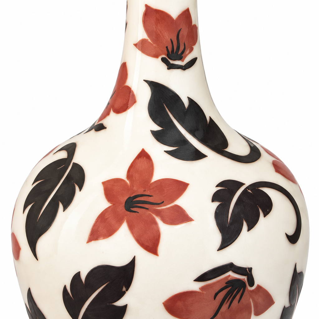 Close-up detail of black scrolling leaves and earthy red flowers on ivory ceramic
