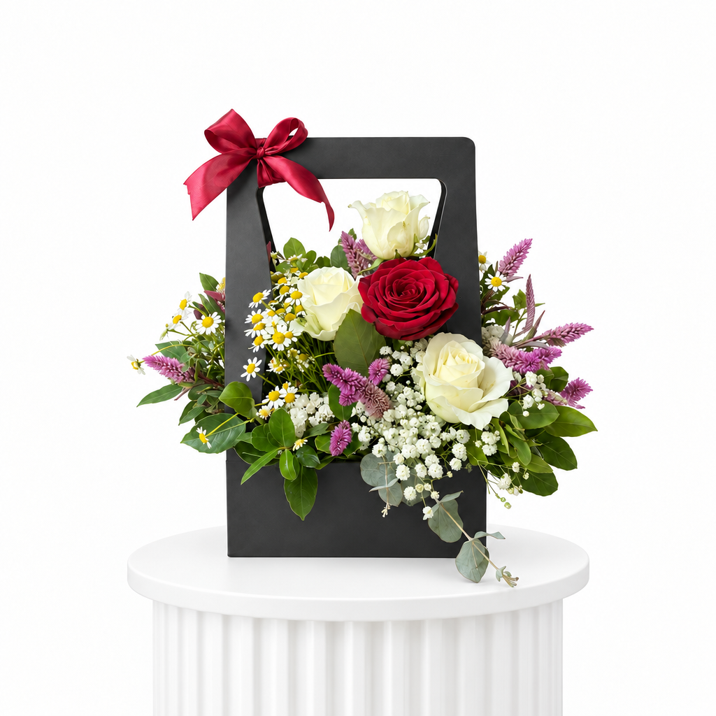 Red and white rose handbag arrangement on a white fluted pedestal