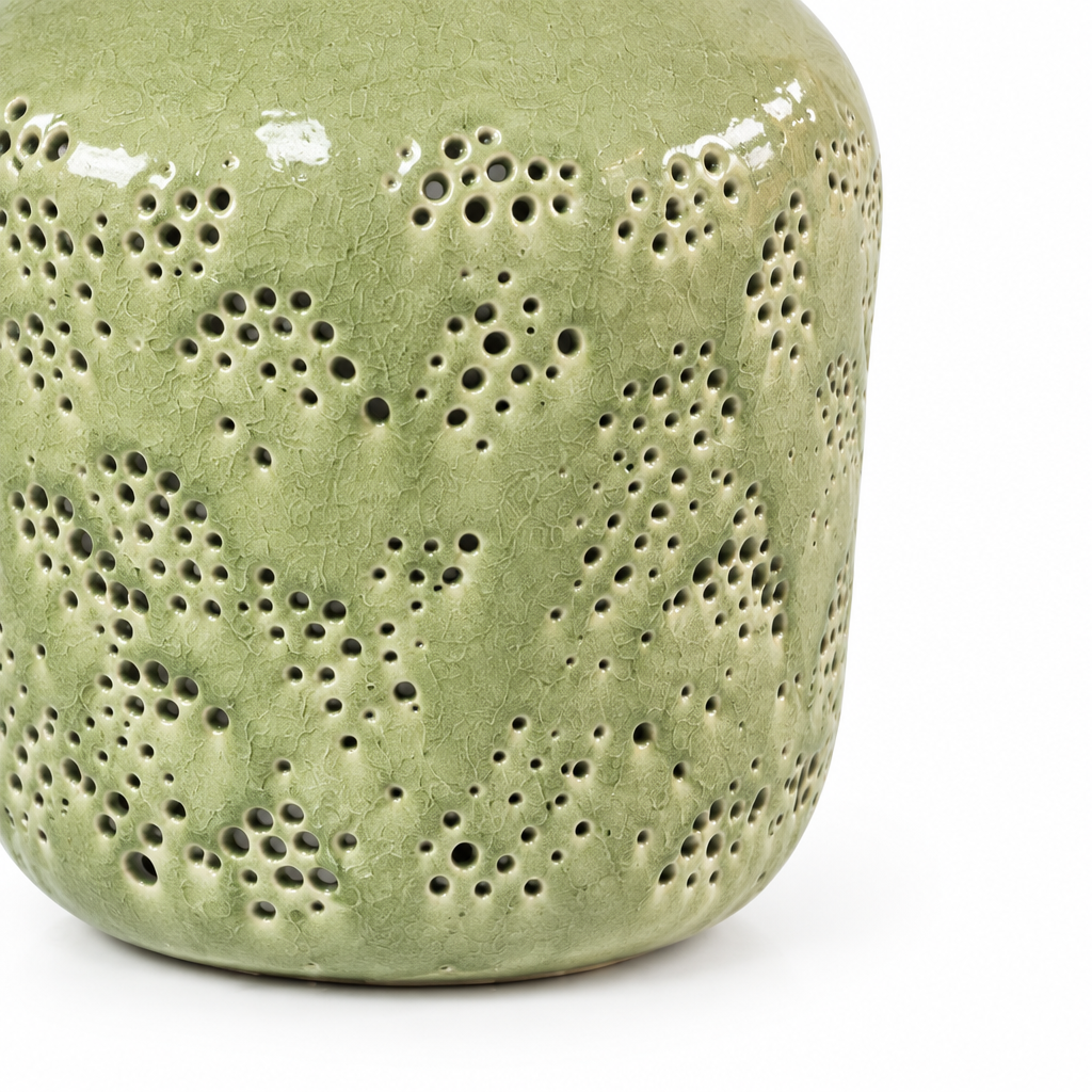 Close-up detail of the pierced dot pattern and textured sage green glaze